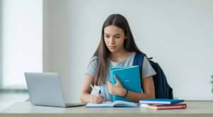 Photorealistic image of a focused high school student planning for college with study materials on a clean desk against a white background
